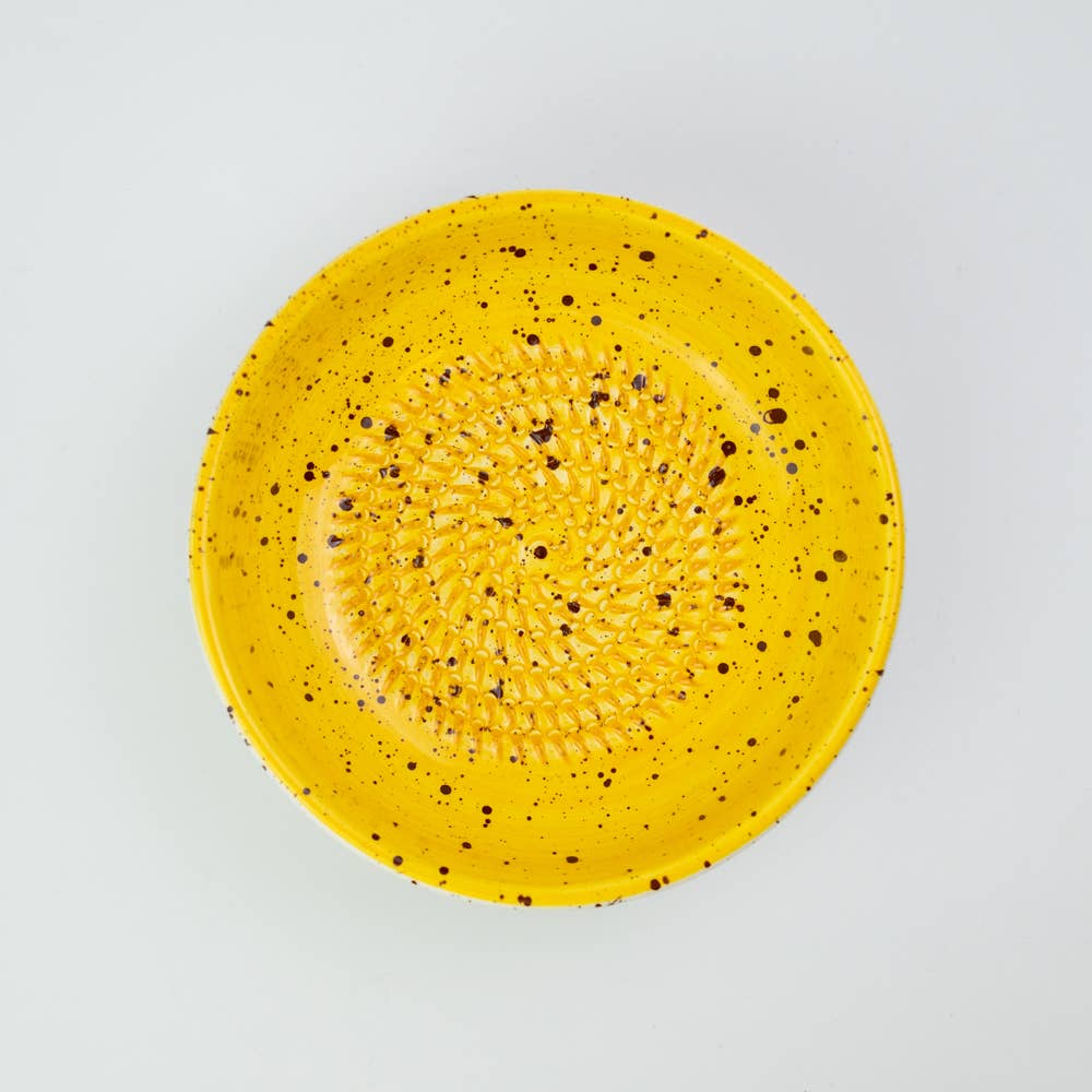 Handmade ceramic grater plate medium in use with ginger