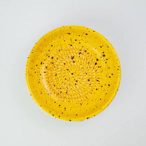 Handmade ceramic grater plate medium in use with ginger