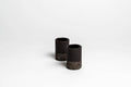 Set of 2 Mezcalitos black clay mezcal cups on cantera stone base
